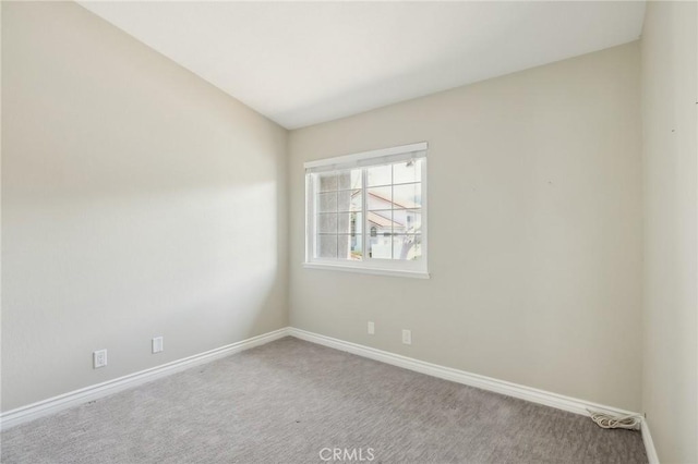 carpeted spare room featuring baseboards