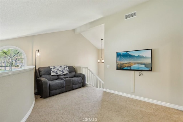 carpeted living room featuring a notable chandelier, visible vents, baseboards, and vaulted ceiling with beams