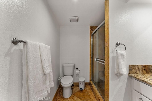 full bathroom with a shower stall, vanity, and toilet