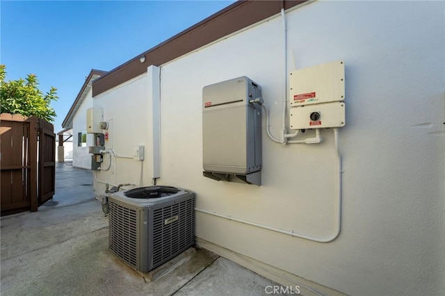 exterior details featuring fence, cooling unit, and stucco siding