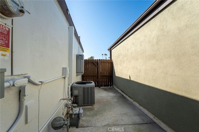 view of property exterior featuring stucco siding, cooling unit, and fence