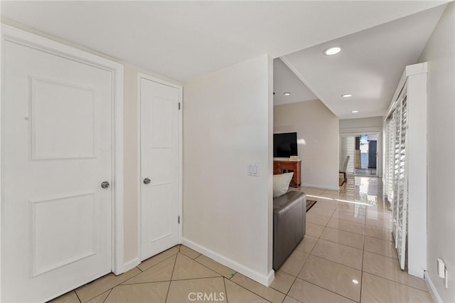 hall with light tile patterned floors, baseboards, and recessed lighting