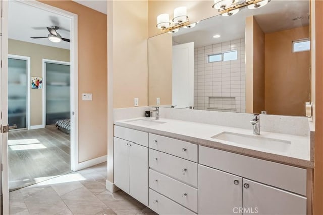bathroom featuring double vanity, baseboards, a sink, and ceiling fan