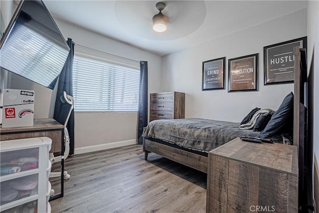 bedroom featuring baseboards, a ceiling fan, and wood finished floors