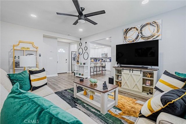 living area featuring recessed lighting, a ceiling fan, and wood finished floors