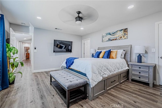 bedroom with recessed lighting, visible vents, baseboards, and wood finished floors