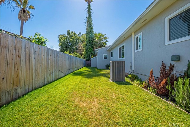 view of yard featuring central AC and fence