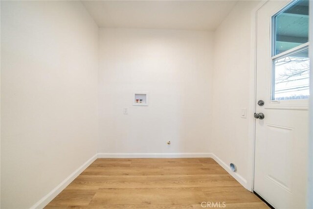 laundry room with washer hookup, baseboards, light wood-type flooring, and laundry area