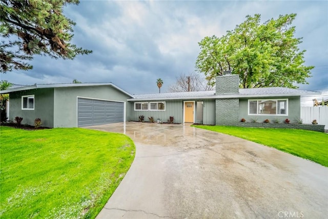 ranch-style house featuring a front lawn, an attached garage, driveway, and a chimney
