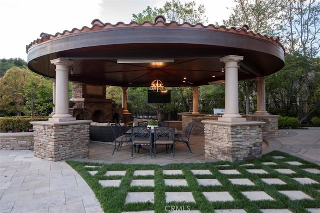 view of patio / terrace with a gazebo and an outdoor stone fireplace