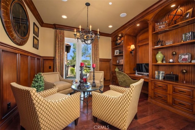sitting room featuring ornamental molding, dark wood finished floors, built in features, a notable chandelier, and wainscoting