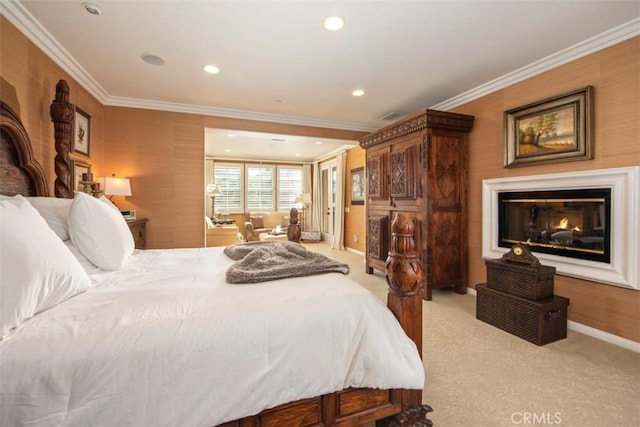 bedroom with light colored carpet, a glass covered fireplace, crown molding, and baseboards