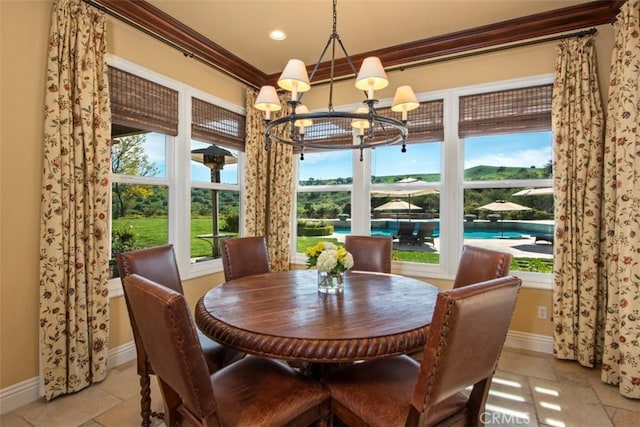 dining room featuring an inviting chandelier, ornamental molding, and baseboards