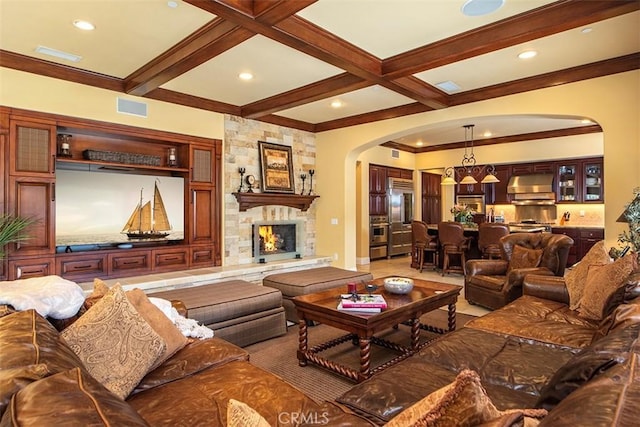 living room featuring visible vents, arched walkways, beam ceiling, ornamental molding, and a stone fireplace