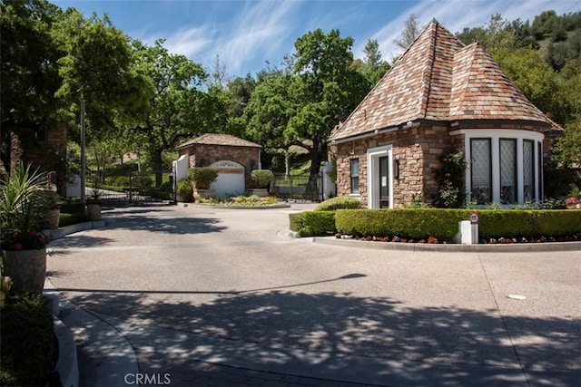 exterior space with a gate, curbs, and a gated entry