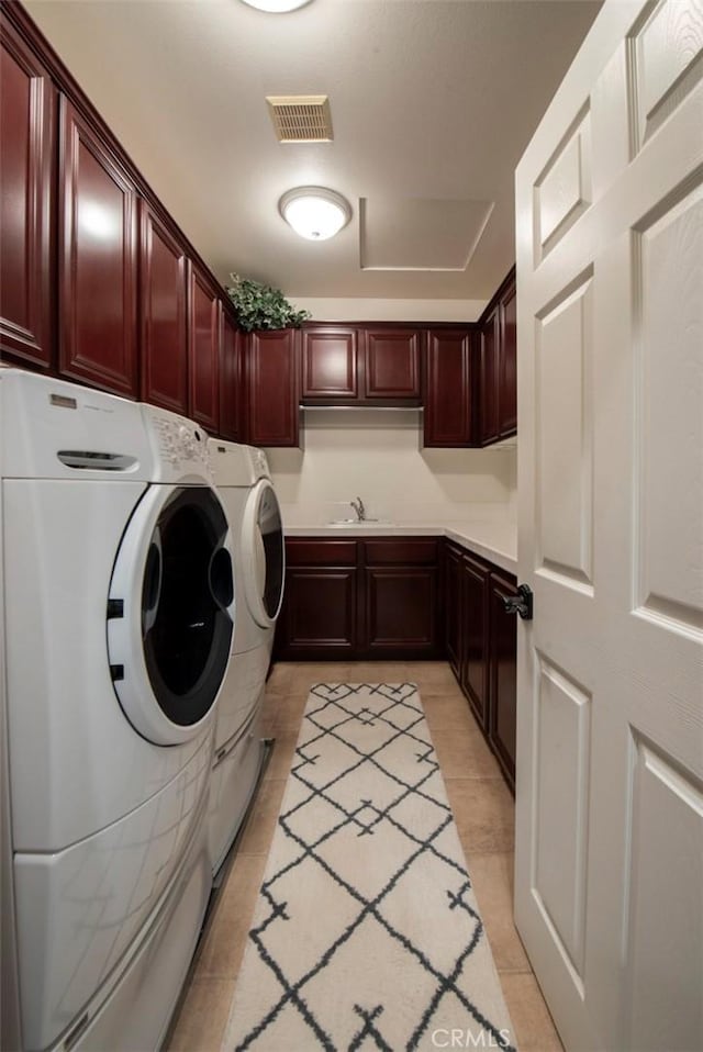 clothes washing area featuring a sink, cabinet space, light tile patterned flooring, visible vents, and washer and dryer