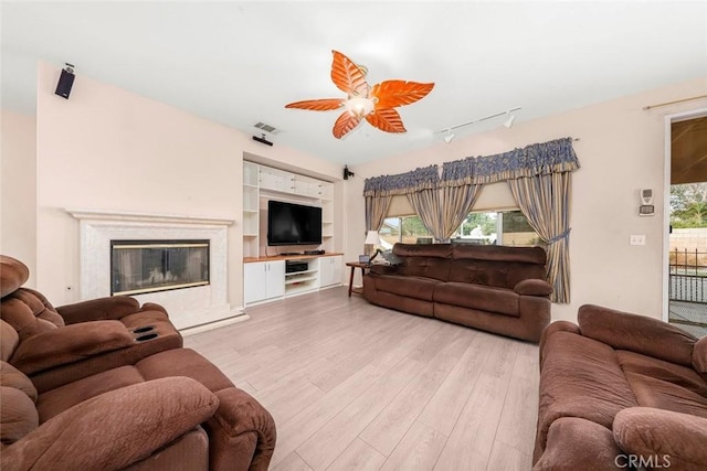 39356 Nicole Dr, Palmdale, CA 93551 - living area with rail lighting, a fireplace, visible vents, ceiling fan, and light wood finished floors
