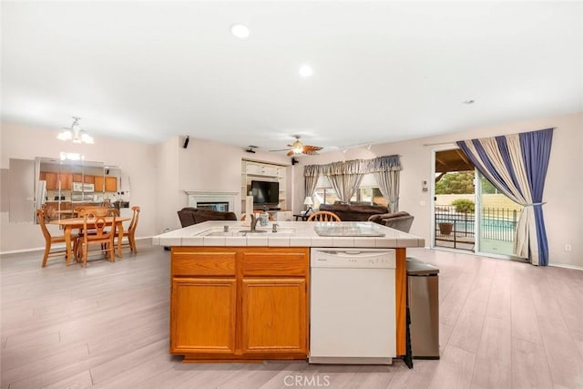 39356 Nicole Dr, Palmdale, CA 93551 - kitchen with open floor plan, white appliances, tile counters, ceiling fan with notable chandelier, and a glass covered fireplace
