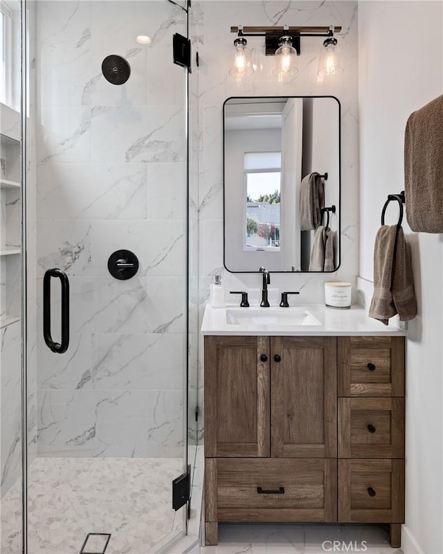 full bath with marble finish floor, vanity, and a marble finish shower