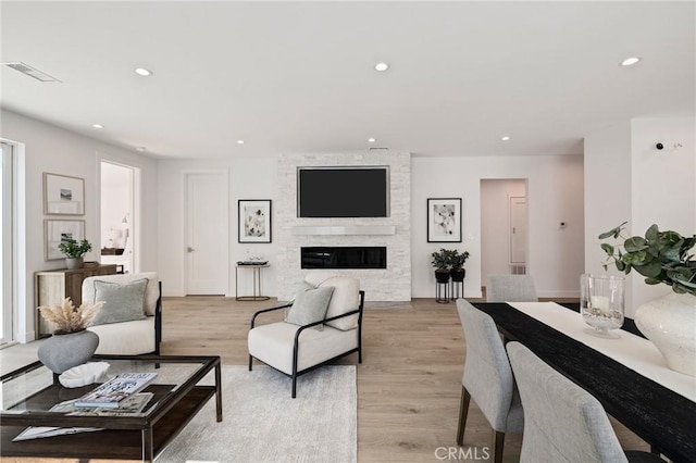 living room with recessed lighting, light wood-style floors, a fireplace, and visible vents