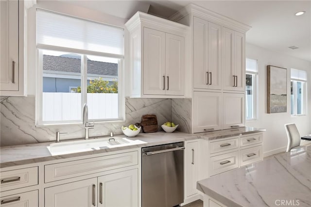 kitchen featuring dishwasher, white cabinetry, decorative backsplash, and a sink