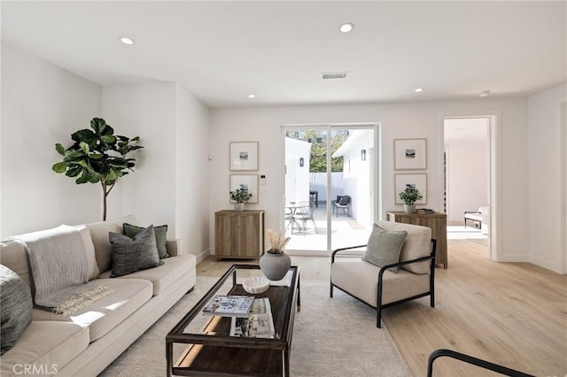 living room with recessed lighting, light wood-style flooring, visible vents, and baseboards