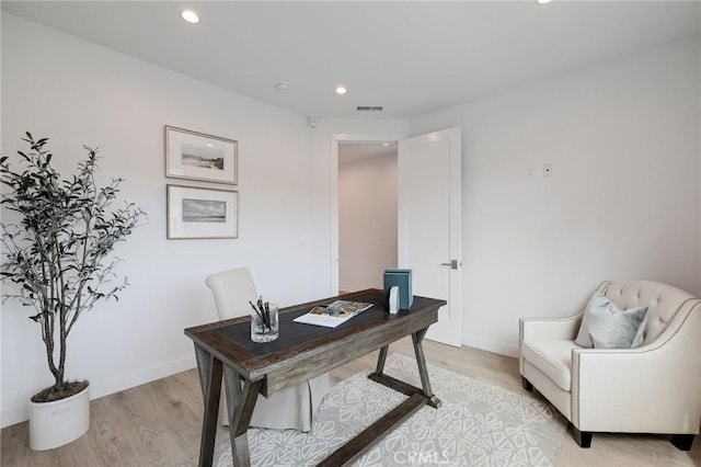 office space with baseboards, light wood-style floors, visible vents, and recessed lighting