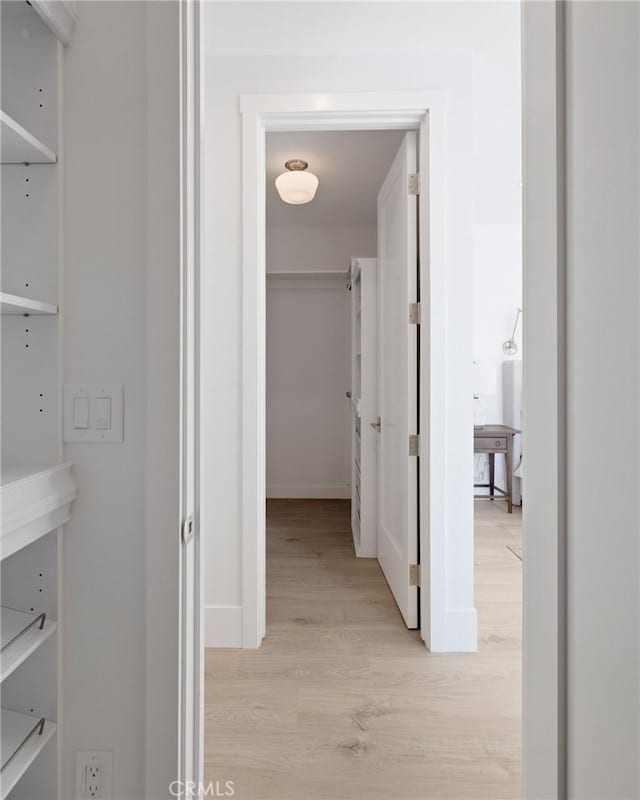 hall featuring light wood-style floors and baseboards