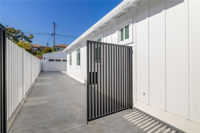 exterior space with fence, an outdoor structure, and a detached garage