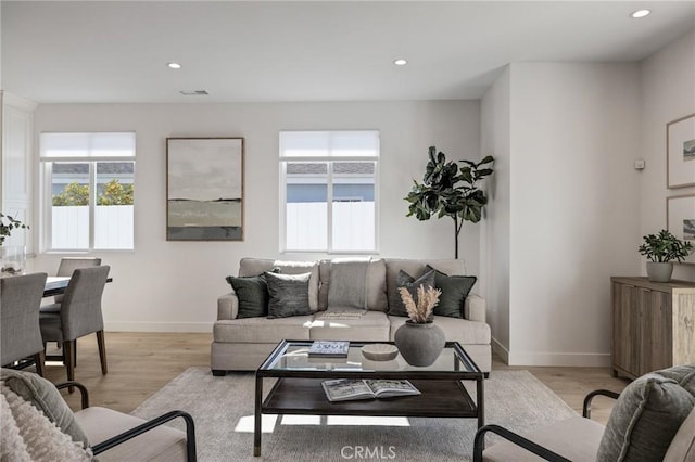 living room with recessed lighting, visible vents, light wood finished floors, and baseboards