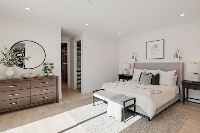 bedroom with baseboards, recessed lighting, and light wood-type flooring