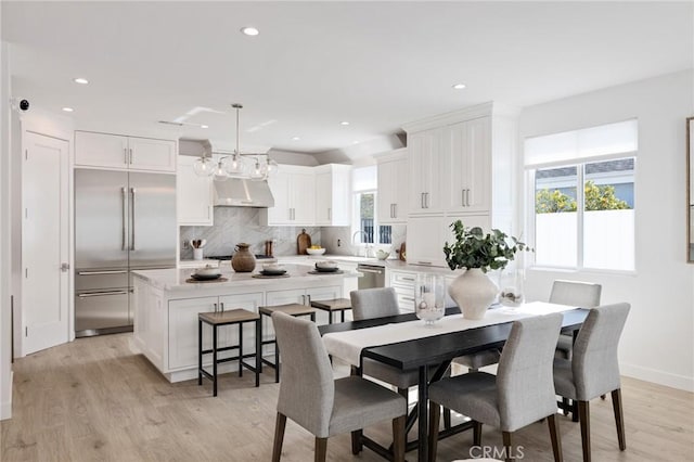 dining space featuring light wood finished floors, baseboards, and recessed lighting