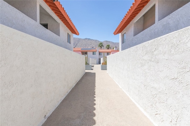 280 S Avenida Caballeros Unit 271, Palm Springs, CA 92262 - view of property exterior featuring stucco siding, a mountain view, and a tiled roof