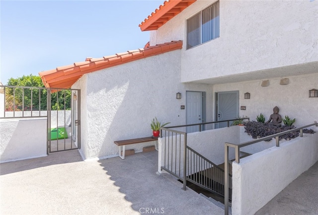 280 S Avenida Caballeros Unit 271, Palm Springs, CA 92262 - doorway to property with a gate, stucco siding, and a tiled roof
