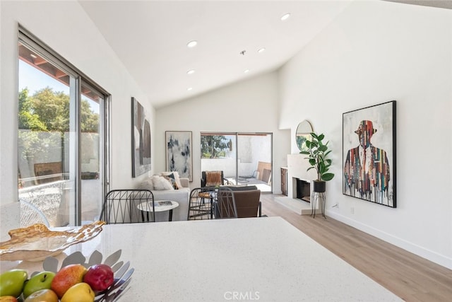 280 S Avenida Caballeros Unit 271, Palm Springs, CA 92262 - bedroom with access to exterior, wood finished floors, multiple windows, a fireplace with raised hearth, and recessed lighting