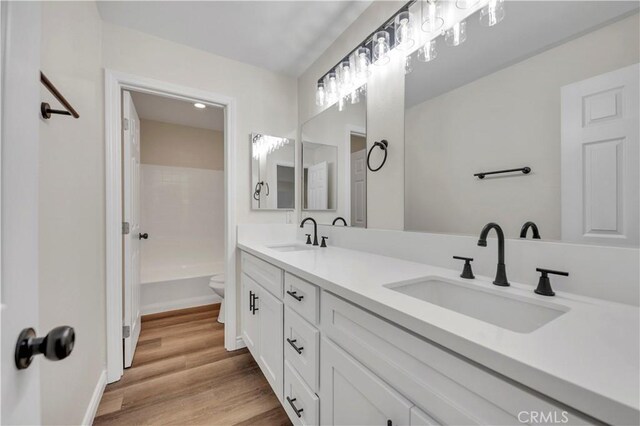 29605 Camino Cristal, Menifee, CA 92584 - bathroom with wood finished floors, a sink, double vanity, and toilet
