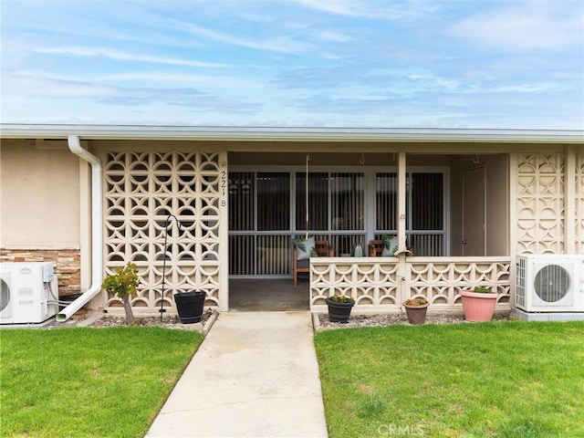 13061 Oak Hill Dr Unit 221B, Seal Beach, CA 90740 - view of exterior entry with a yard, ac unit, and stucco siding