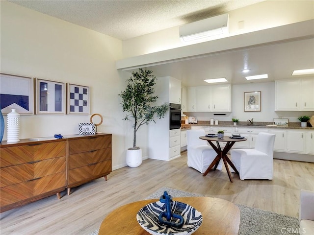 13061 Oak Hill Dr Unit 221B, Seal Beach, CA 90740 - interior space featuring light wood-type flooring, white cabinetry, light countertops, a sink, and black oven