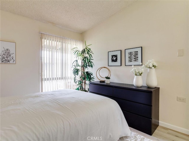 13061 Oak Hill Dr Unit 221B, Seal Beach, CA 90740 - bedroom featuring baseboards, light wood-style floors, and a textured ceiling