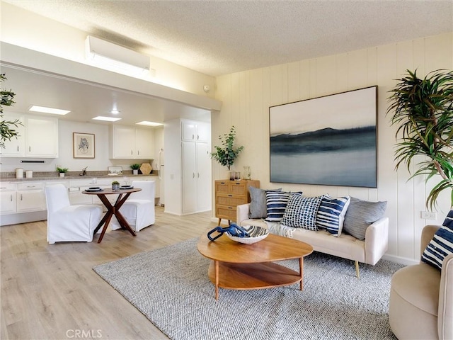 13061 Oak Hill Dr Unit 221B, Seal Beach, CA 90740 - living room with light wood-style floors and a textured ceiling