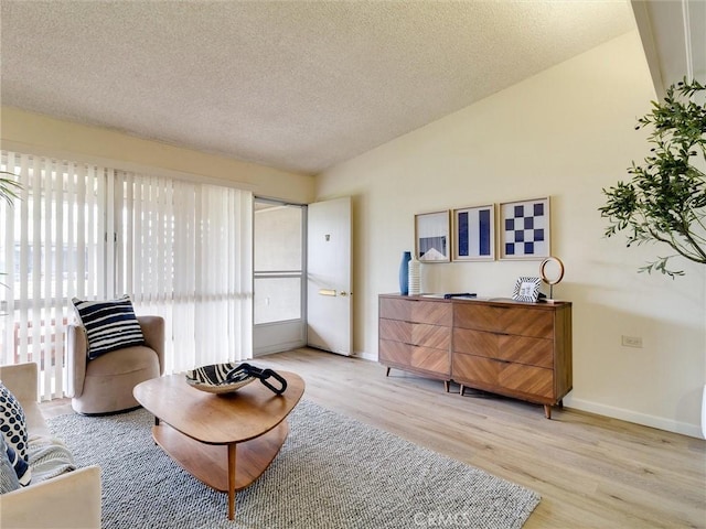13061 Oak Hill Dr Unit 221B, Seal Beach, CA 90740 - living area featuring light wood-type flooring, baseboards, vaulted ceiling, and a textured ceiling
