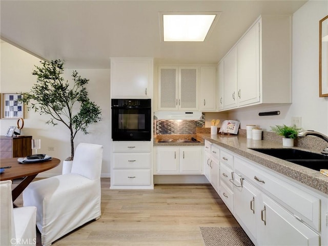 13061 Oak Hill Dr Unit 221B, Seal Beach, CA 90740 - kitchen featuring light wood-style floors, white cabinets, electric cooktop, a sink, and oven