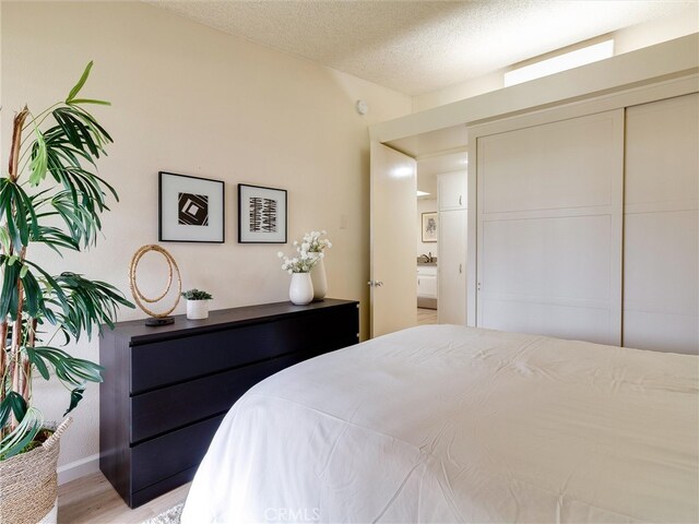13061 Oak Hill Dr Unit 221B, Seal Beach, CA 90740 - bedroom with light wood-style floors, baseboards, and a textured ceiling