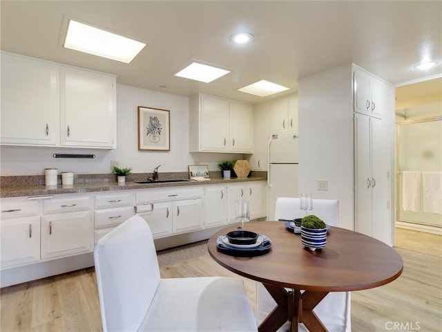 13061 Oak Hill Dr Unit 221B, Seal Beach, CA 90740 - kitchen with white cabinets, a sink, freestanding refrigerator, recessed lighting, and light wood finished floors