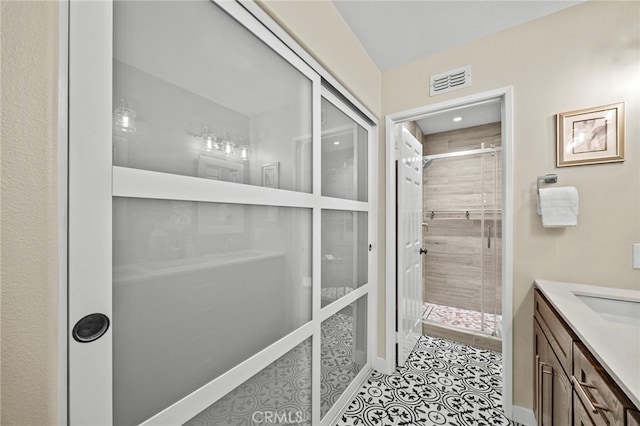 full bath featuring a shower stall, visible vents, vanity, and tile patterned floors