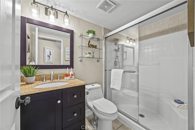 bathroom featuring toilet, a stall shower, visible vents, tile patterned flooring, and vanity
