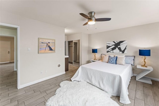 bedroom with baseboards, wood finish floors, a closet, and ceiling fan