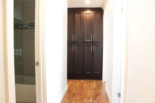 corridor featuring recessed lighting, baseboards, and light wood finished floors