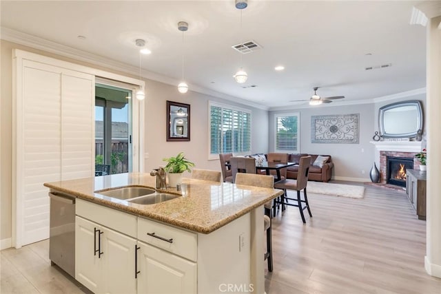 17963 Passionflower Ln, San Bernardino, CA 92407 - kitchen with dishwasher, baseboards, a kitchen island with sink, light wood finished floors, and ornamental molding