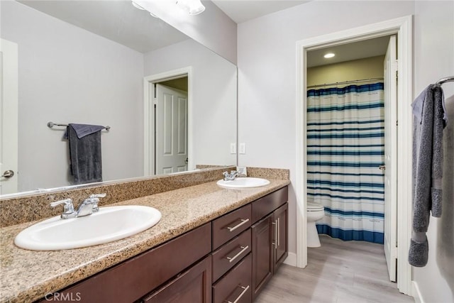17963 Passionflower Ln, San Bernardino, CA 92407 - bathroom featuring wood finished floors, toilet, double vanity, and a shower with shower curtain